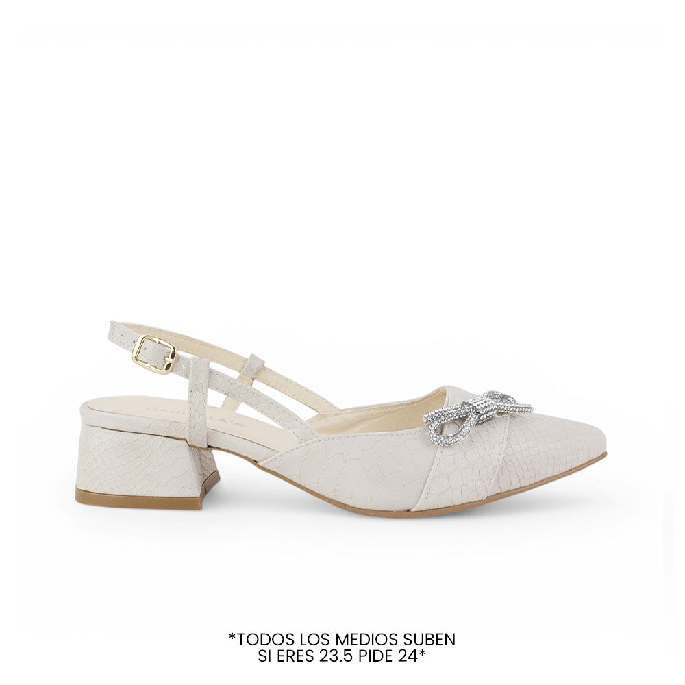 Vista lateral de zapatilla beige destalonada para mujer con moño de pedrería punta fina cerrada y tacón bajo de 4cm