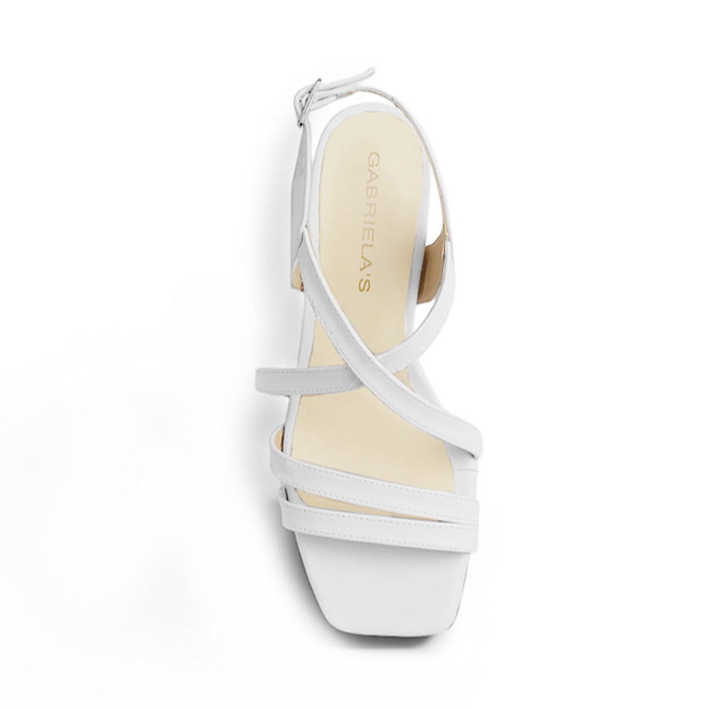 Vista superior de zapatilla blanca para mujer con tiras cruzadas de ajuste con hebilla rectangular y punta cuadrada