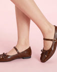 Flats tipo balerinas cafés de piso para dama con moño y pulsera ajustable en el empeine.