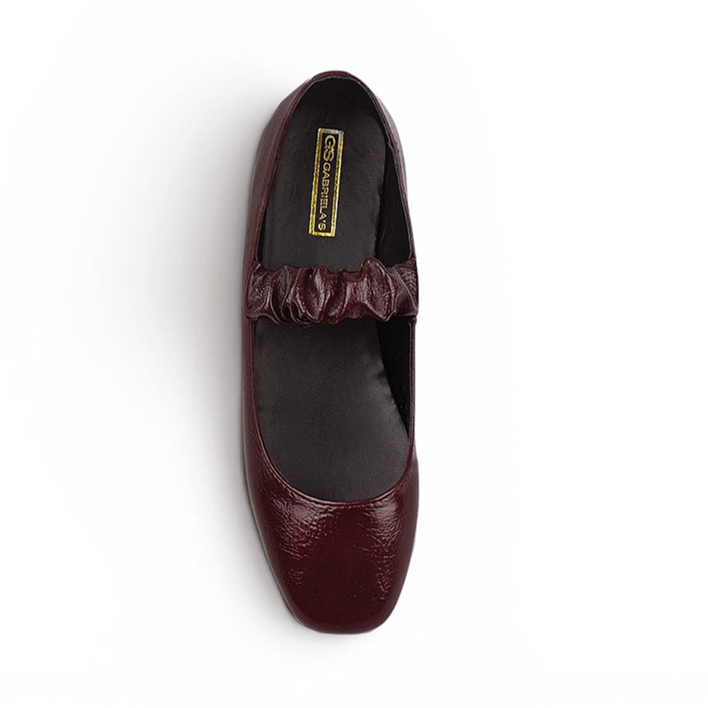 Vista superior de flats tipo balerinas vino con pulsera elástica de piso para dama 
