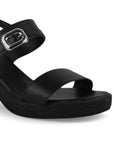 Vista a detalle de hebilla que adorna la doble tira en zapatilla negra descubierta para mujer 