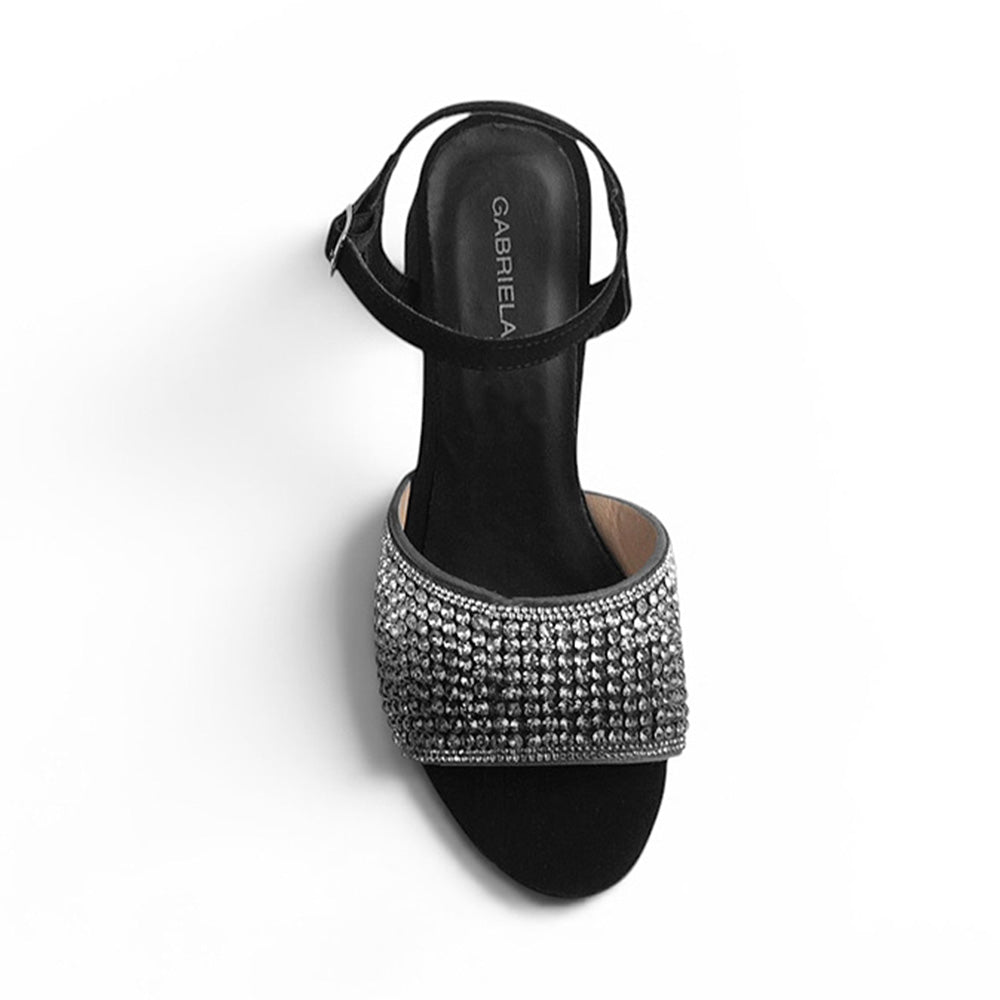 Vista superior de zapatilla de diseño descubierto para mujer de tira ancha con pedrería y tacón ancho medio de 7cm en color negro