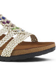 detalle del material sintético de las sandalias beige para dama con tiras trenzadas y detalles multicolor  para dama  de piso
