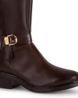 Detalle del material sintético en la bota café para dama con herraje metálico decorativo y tacón bajo 4cm  