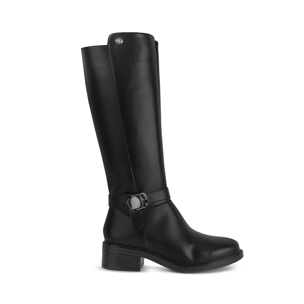 Vista lateral de la bota negra clásica con detalles metálicos decorativos y tacón bajo 4cm para dama