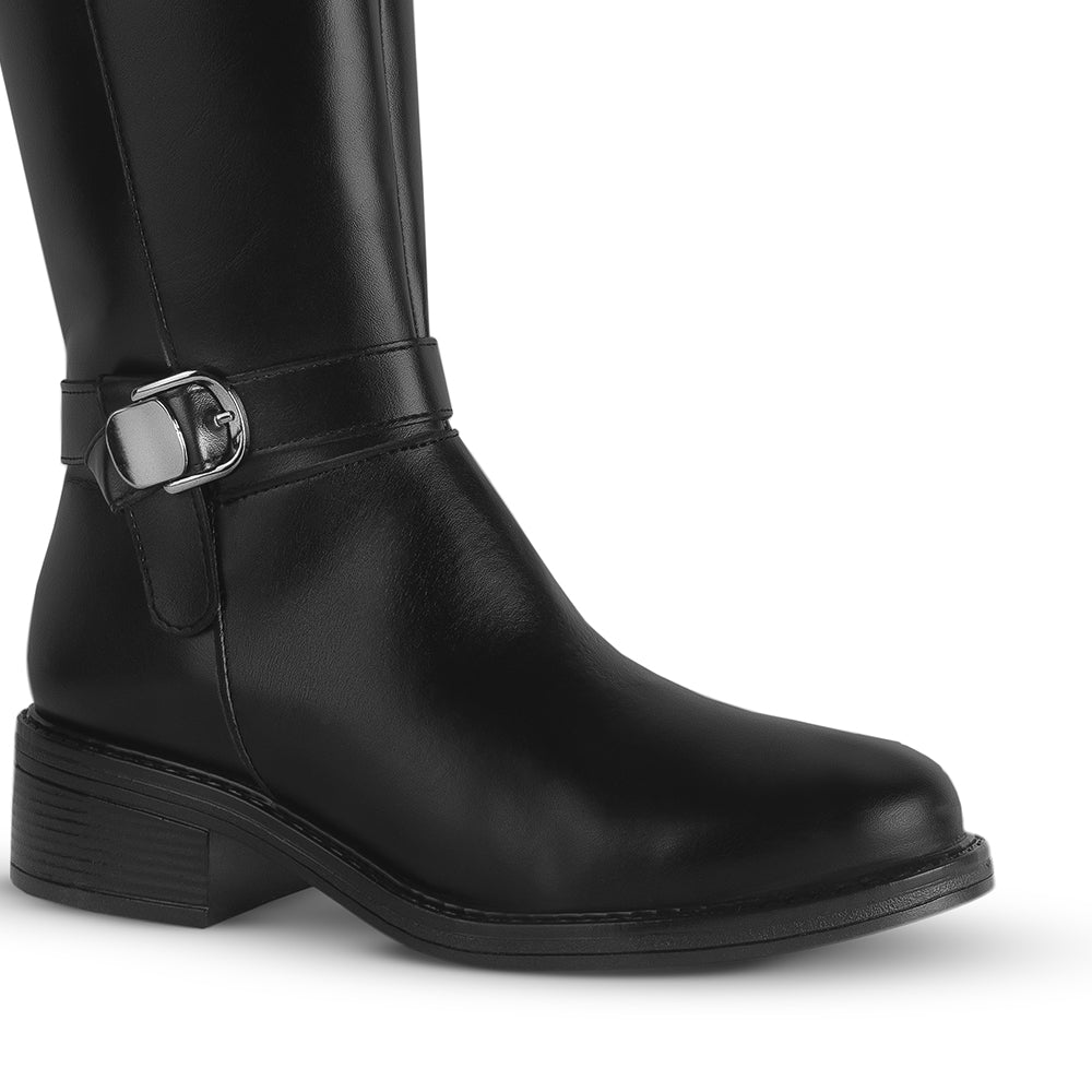 Detalle del material sintético en la bota negra para dama con herraje metálico decorativo y tacón bajo 4cm  
