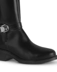 Detalle del material sintético en la bota negra para dama con herraje metálico decorativo y tacón bajo 4cm  
