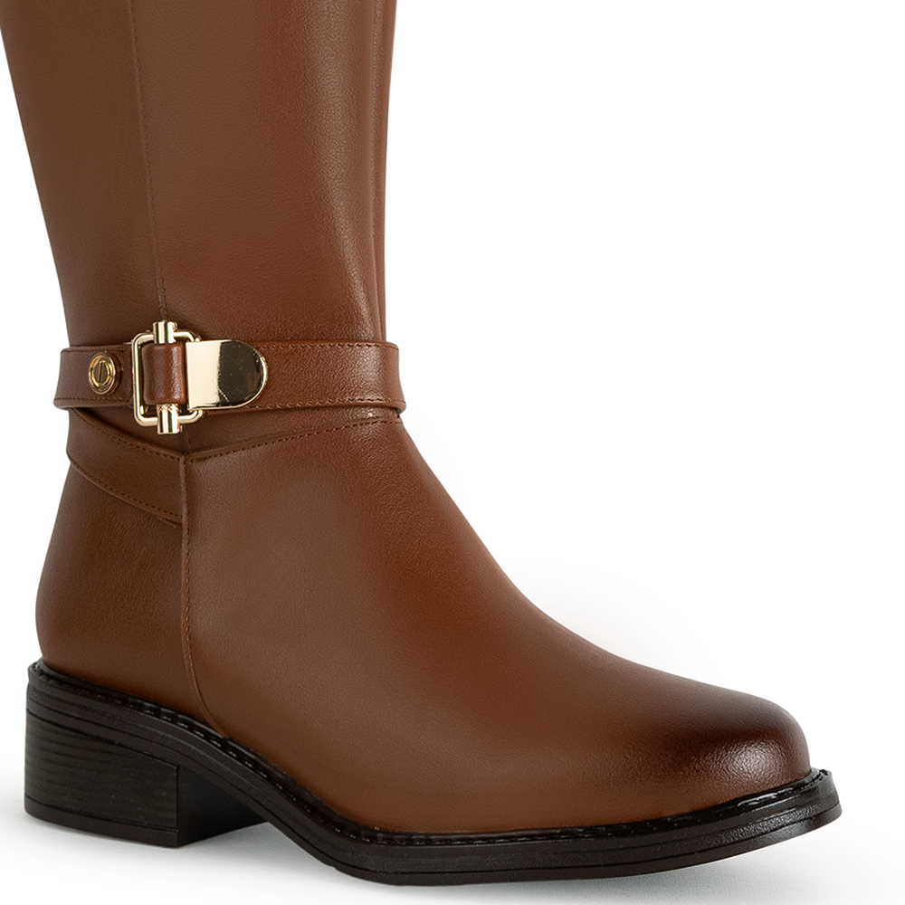 Detalle del material sintético en la bota café para dama con herraje metálico decorativo y tacón bajo 4cm  