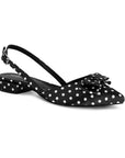 Vista diagonal de zapatilla negra con lunares blancos, tacón bajo 3cm, pulsera ajustable y moño decorativo 