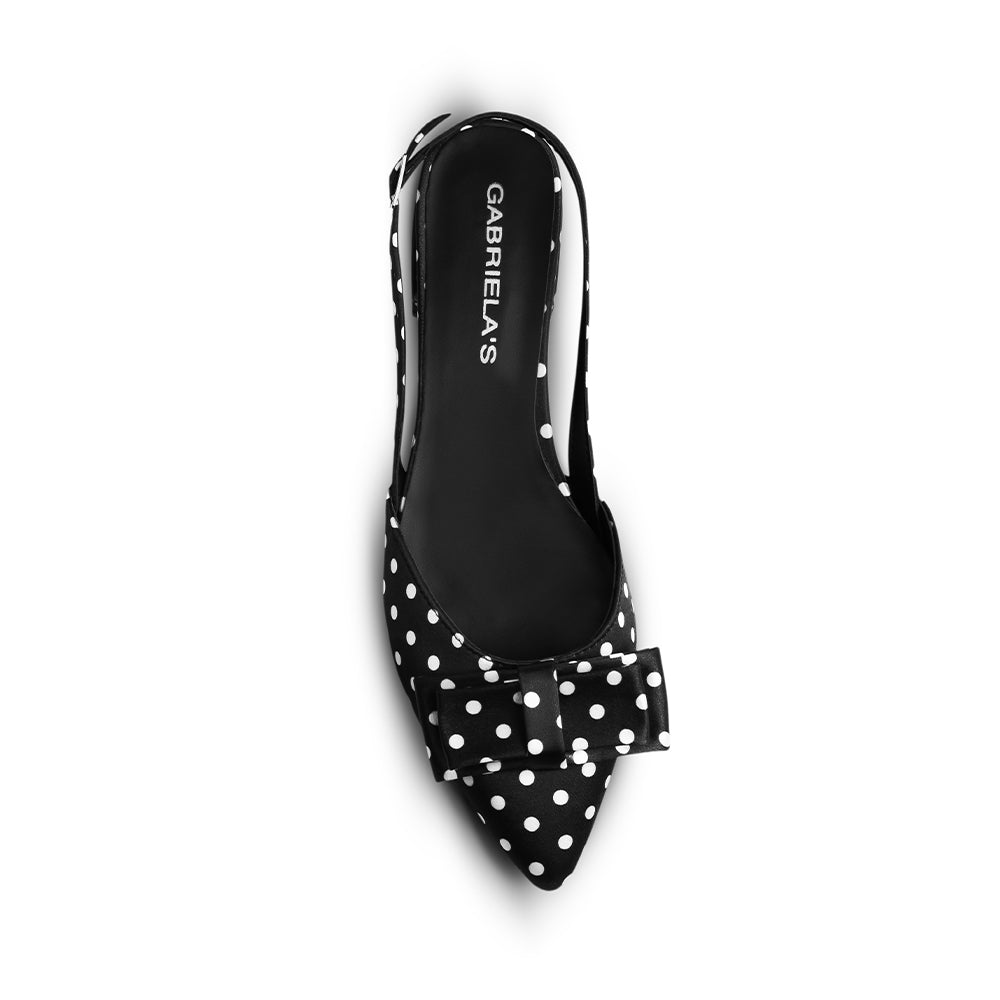 Vista superior en la zapatilla negra con lunares de punta fina y moño decorativo para dama 