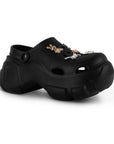 Vista diagonal en la sandalia tipo clog con pulsera ajustable, plataforma media 7cm y charms decorativos para dama 