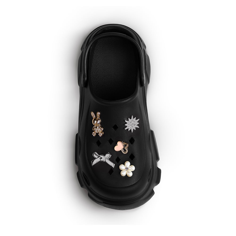 Vista superior en sandalia negra tipo clog con punta redonda charms decorativos y pulsera ajustable para dama 