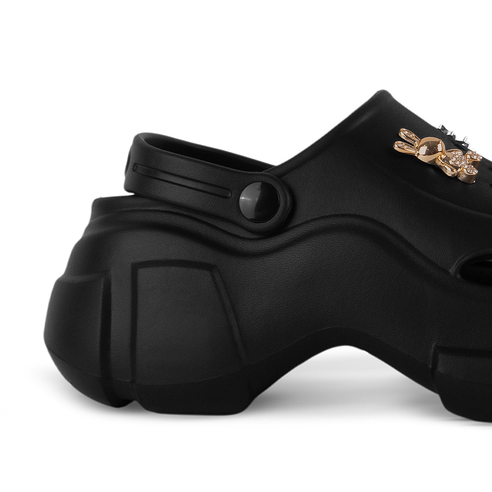 Vista trasera de la plataforma media 7cm en la sandalia negra con pulsera ajustable y charms decorativos para dama 