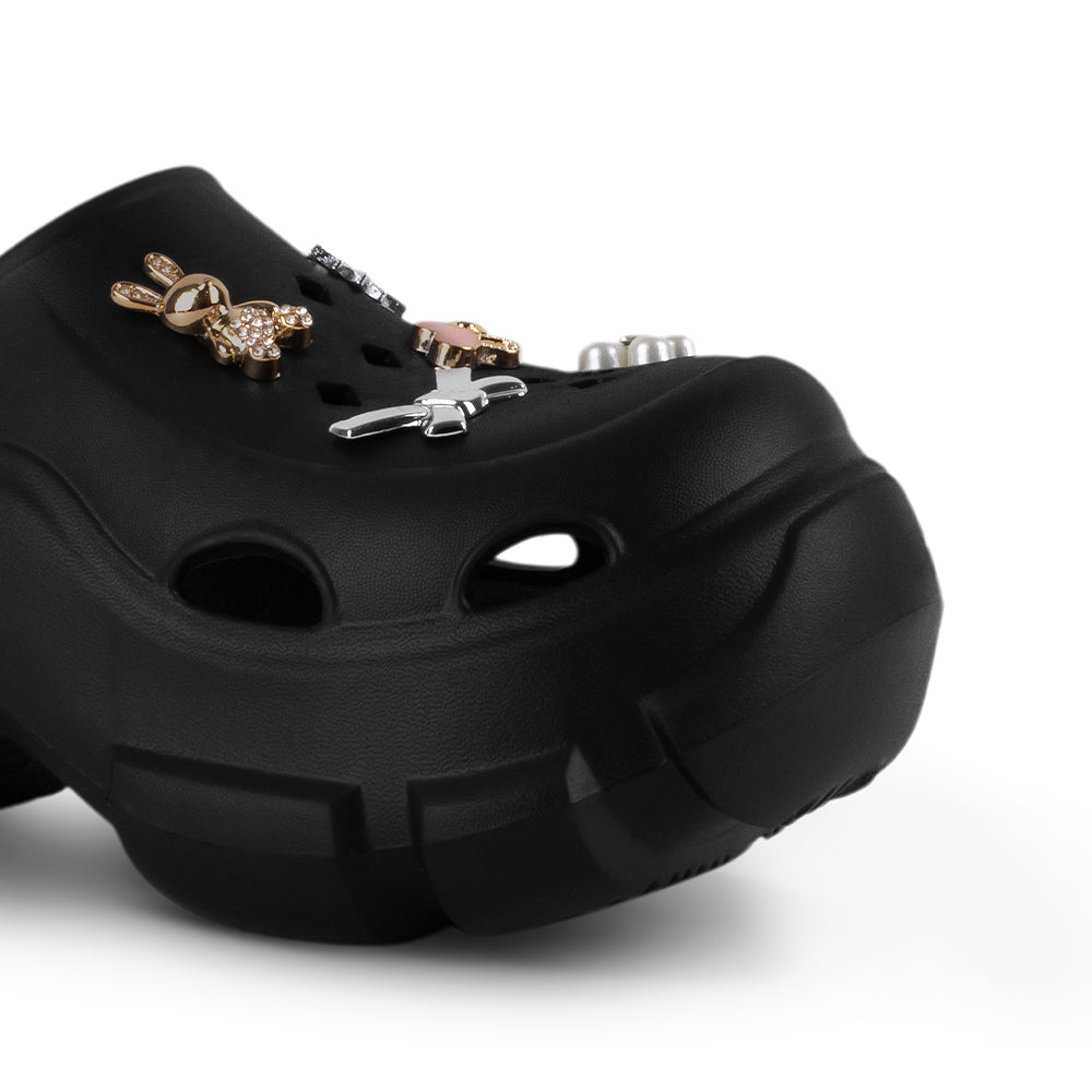Detalle del material sintético en sandalia negra tipo clog para dama con plataforma media 7cm y charms decorativos  