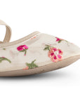 Detalle del material sintético y fresco en los flats tipo balerina nude de dama con flores bordadas