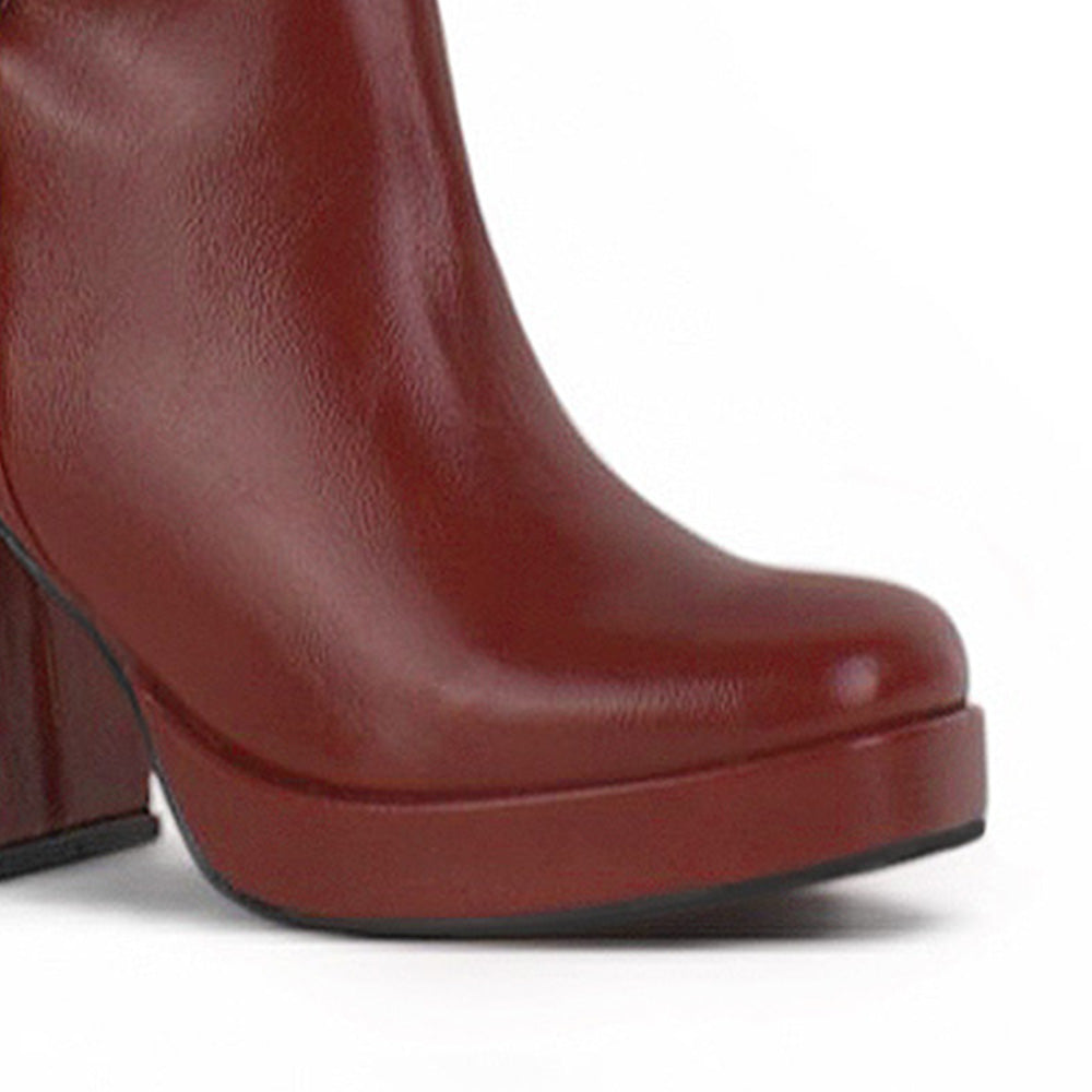Detalle del material sintético en la bota vino con herraje metálico,  plataforma y tacón medio 9 cm para dama 