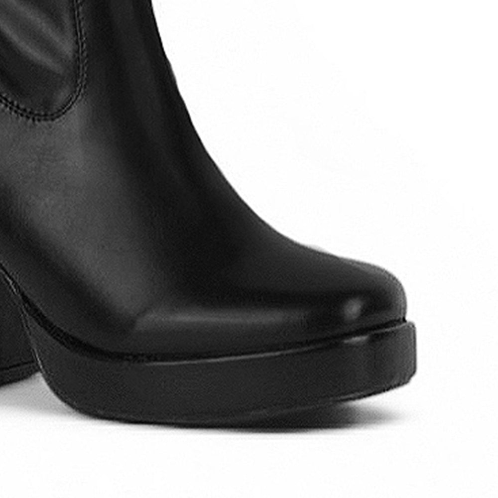 Detalle del material sintético en la bota negra con plataforma y tacón medio 9 cm para dama 