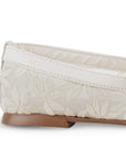 Vista trasera de flats tipo balerinas beige de piso para mujer con hebilla moderna en pulsera ajustable sobre el empeine y bordado de flores