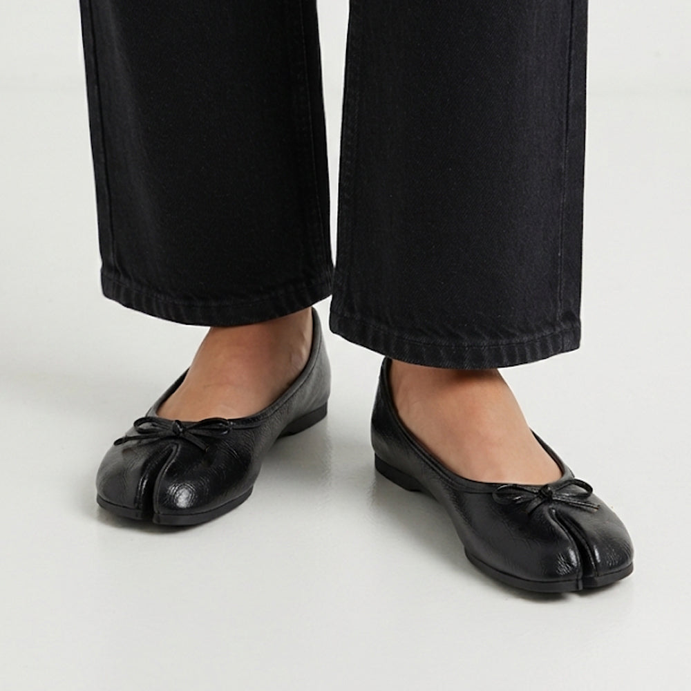 Flats negros tipo tabi con punta dividida, moño decorativo y suela de piso para dama