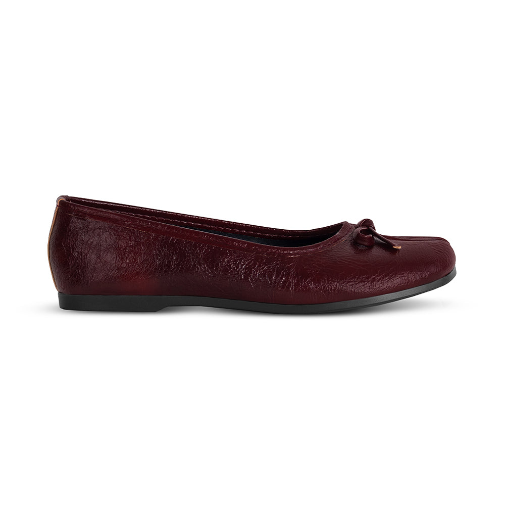 Vista lateral en flats vino tipo tabi con suela de piso y moño decorativo para dama 