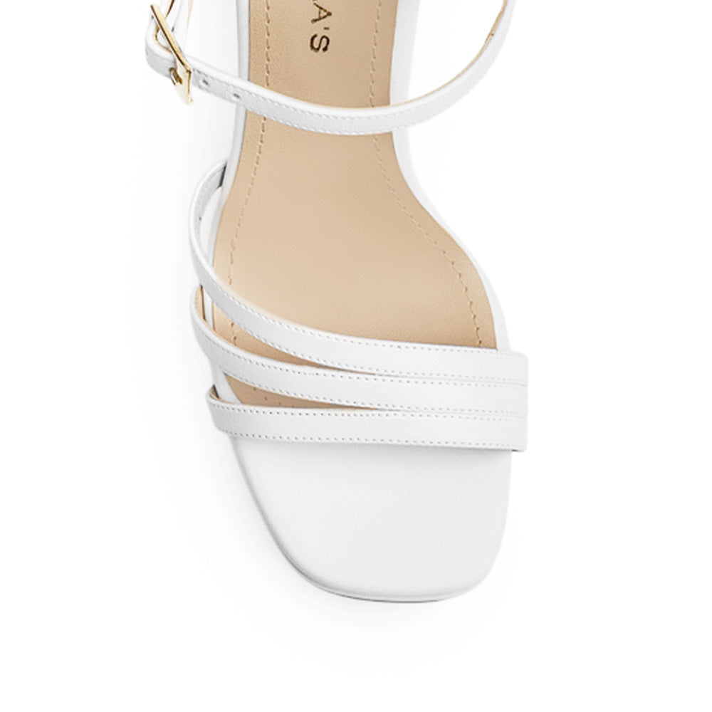 Vista de material cabra sintético en zapatilla blanca para mujer con tiras cruzadas y tacón alto de 11cm 