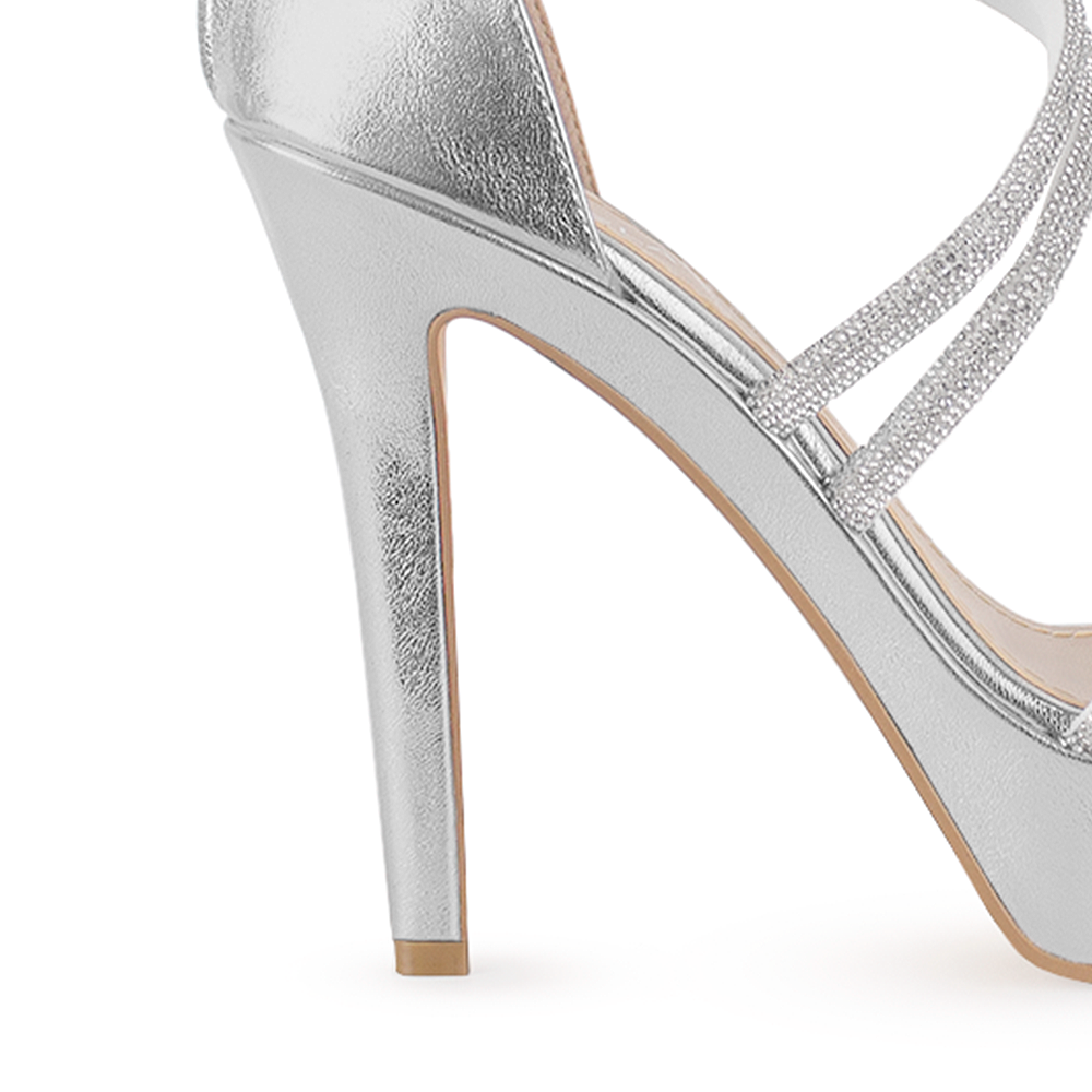 Vista de material sintético en zapatilla para mujer con tiras de pedrería y tacón delgado de 12cm en color plateado