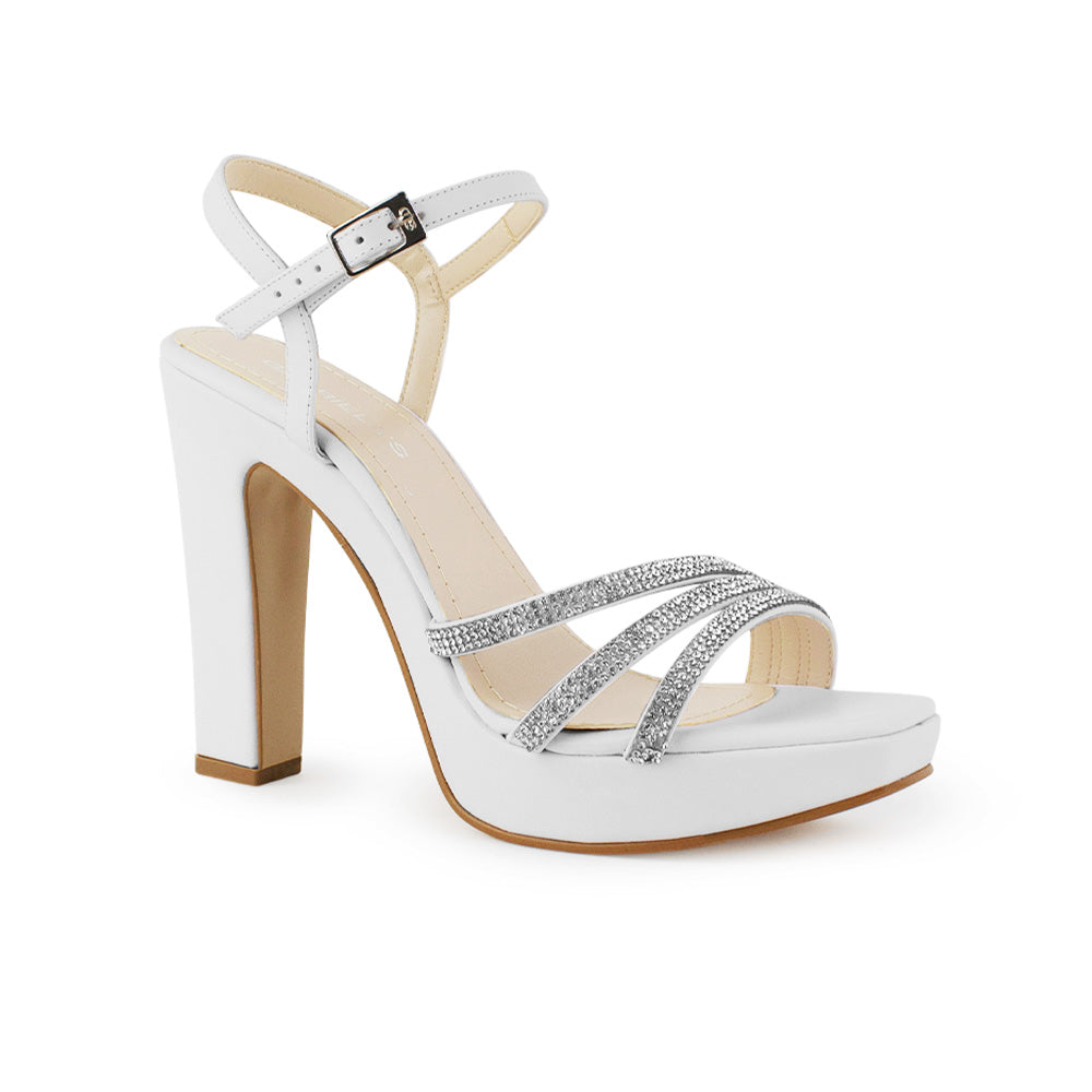 Vista diagonal de zapatilla blanca para mujer con pulsera ajustable tiras cruzadas de pedrería y tacón alto de 11cm