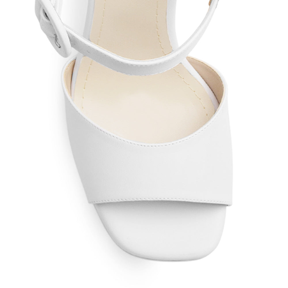 Vista de material cabra sintético en zapatilla blanca para mujer con pulsera al tobillo hebilla forrada y tacón alto de 11cm