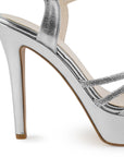 Vista trasera de tacón alto delgado de 13cm en zapatilla plateada de diseño descubierto para mujer con pedrería y pulsera ajustable al tobillo