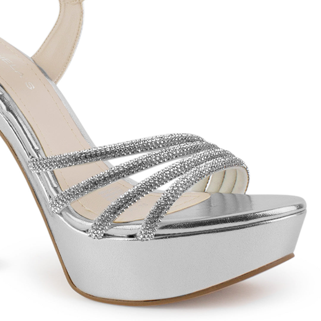 Vista a detalle de tiras con pedrería zapatilla plateada para mujer con pulsera ajustable y tacón alto delgado de 13cm