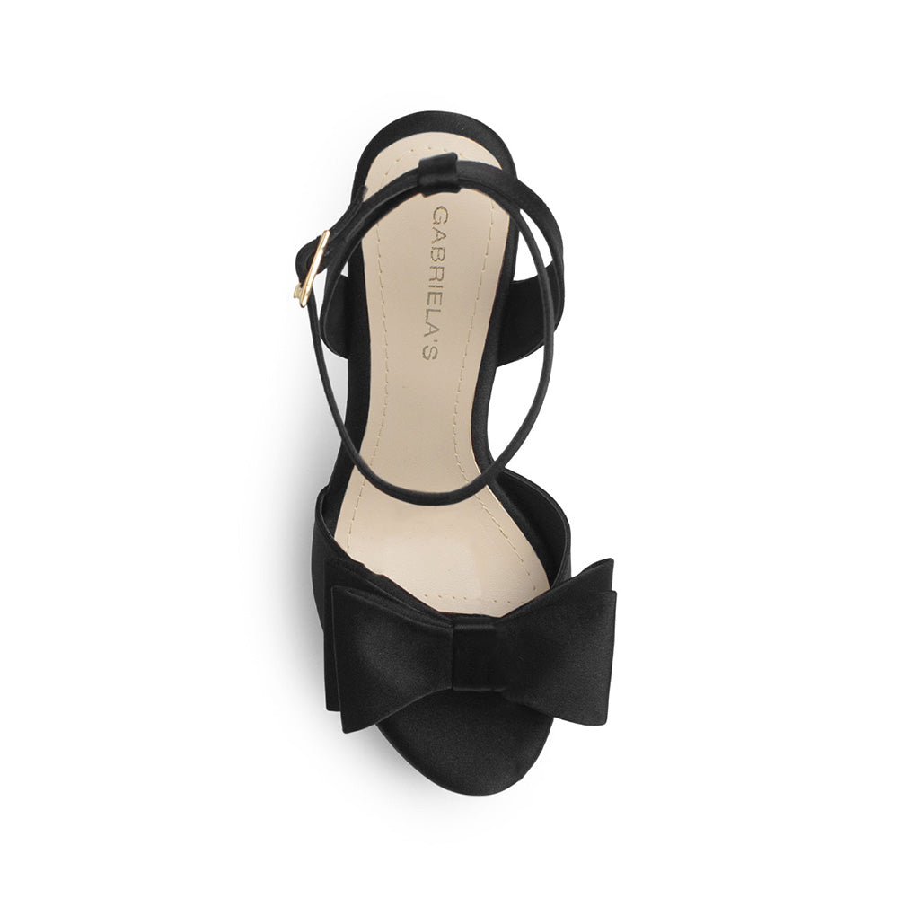 Vista superior de zapatilla negra con moño, plataforma, punta abierta pulsera ajustable y tacón alto 12cm para dama