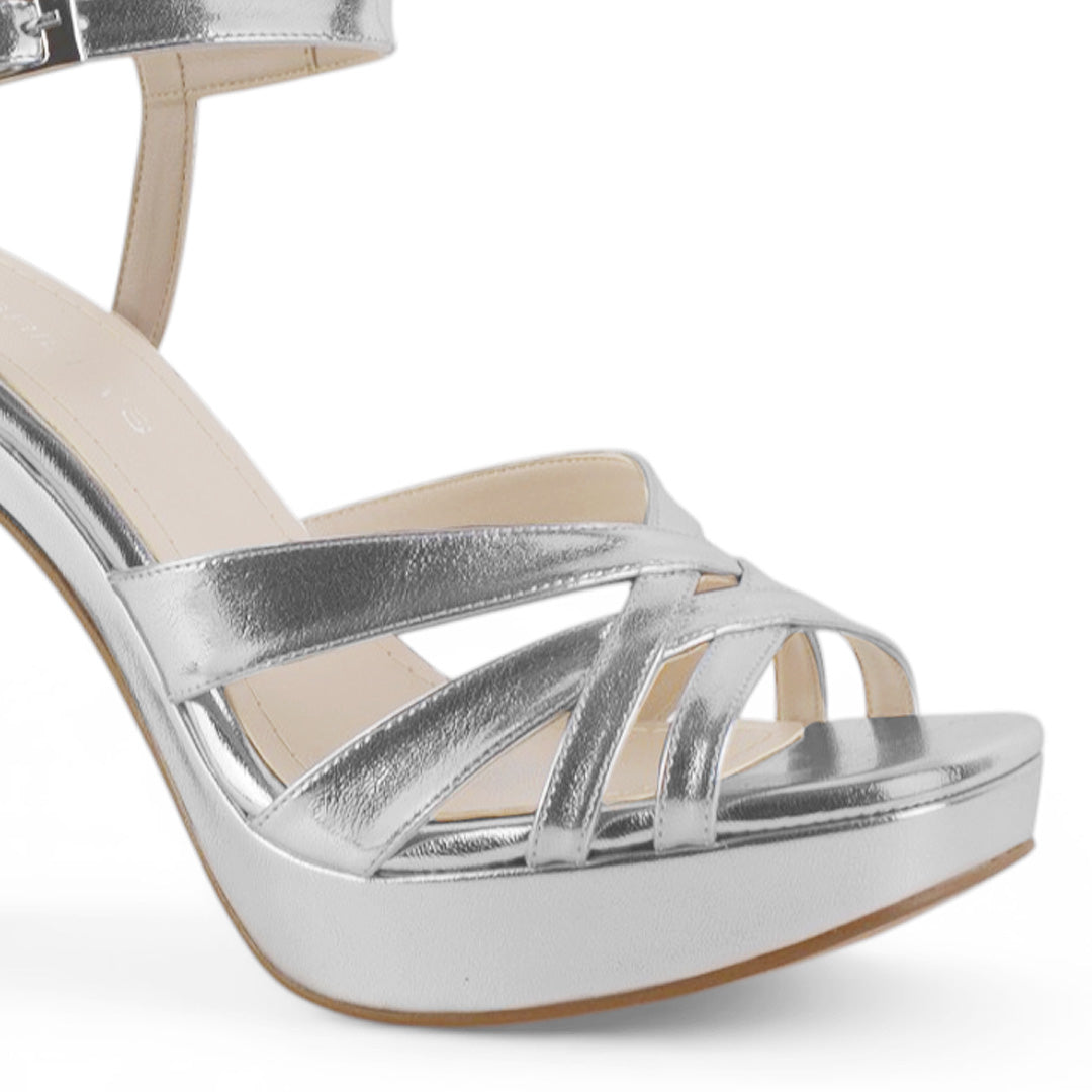 Vista a detalle de tiras entrelazadas en zapatilla plateada para mujer con plataforma frontal tacón alto de 12cm y pulsera ajustable 