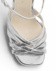 Vista de material sintético en zapatilla de diseño descubierto para mujer con tiras cruzadas pulsera ajustable y tacón alto de 12cm en color plata