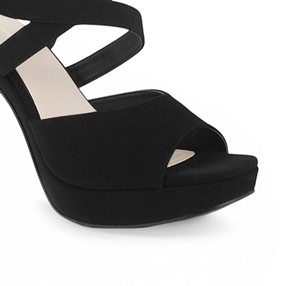 Vista a detalle de zapatilla de diseño descubierto para mujer con pulsera ajustable y tacón alto delgado de 12cm en color negro