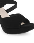 Vista a detalle de zapatilla de diseño descubierto para mujer con pulsera ajustable y tacón alto delgado de 12cm en color negro