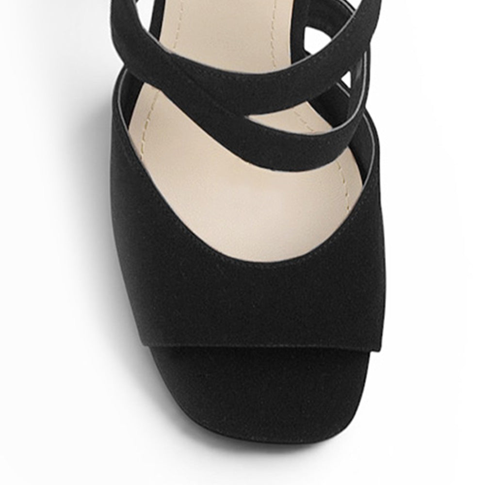 Vista de material buck en zapatilla negra de diseño descubierto con pulsera ajustable y tacón delgado de 12cm