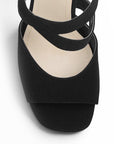Vista de material buck en zapatilla negra de diseño descubierto con pulsera ajustable y tacón delgado de 12cm