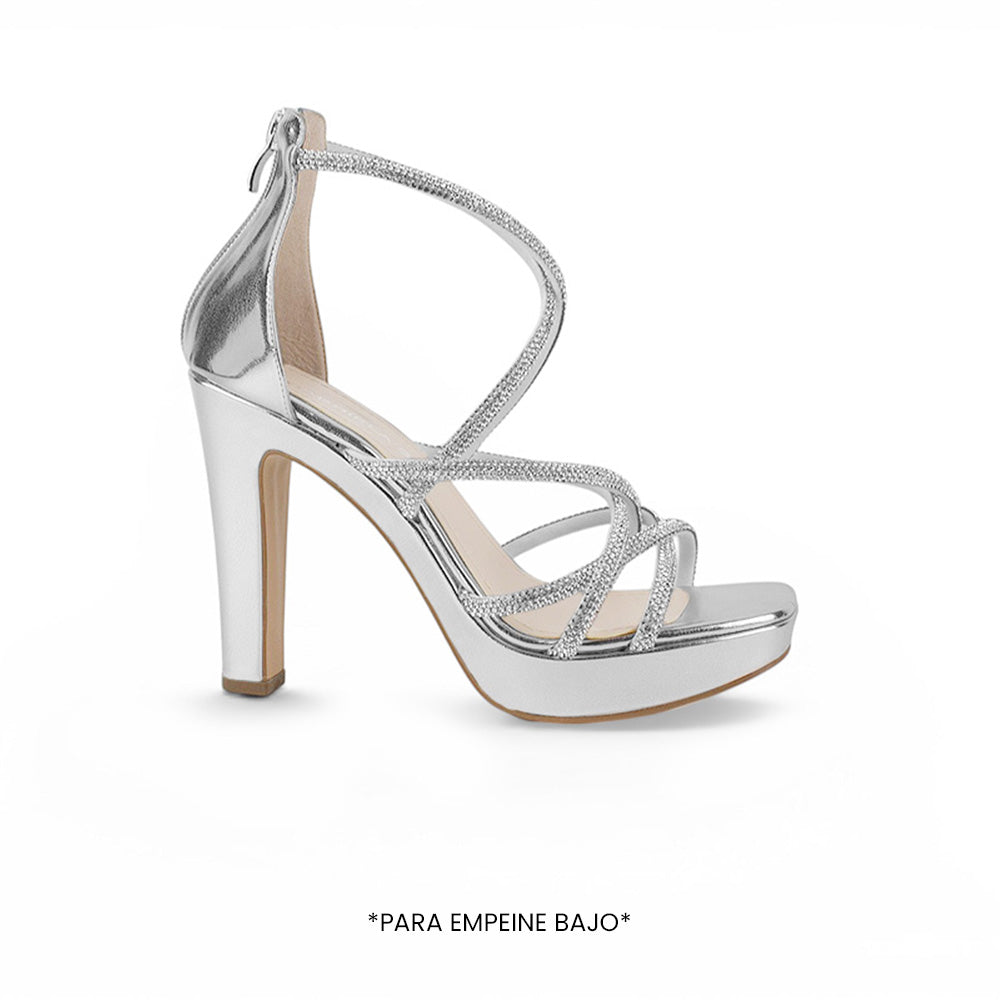 Vista lateral de zapatilla plateada con plataforma,tiras de pedrería y ajuste con cremallera tacón alto 11 cm