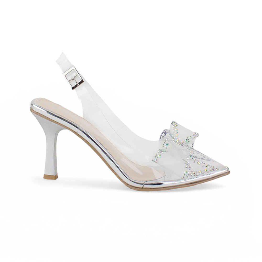 Vista lateral de zapatillas plateadas transparentes para mujer de diseño destalonado con correa ajustable punta fina moño de pedrería y tacón de 9cm