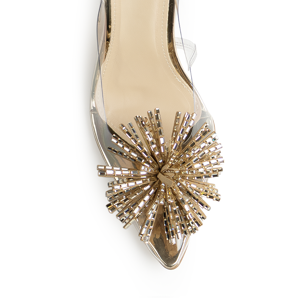 Vista de material sintético en zapatilla dorada transparente destalonada para mujer con pedrería en punta fina tipo stiletto y tacón delgado de 9cm 