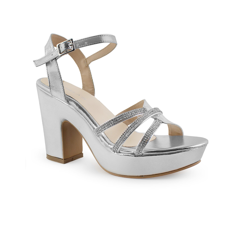 Vista diagonal de zapatilla plateada
para mujer de plataforma con tacón ancho medio de 10cm tiras cruzadas con pedrería y pulsera ajustable 