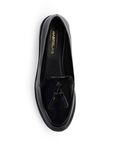 Vista superior del mocasín negro de charol con borlas decorativas para dama y suela de piso 