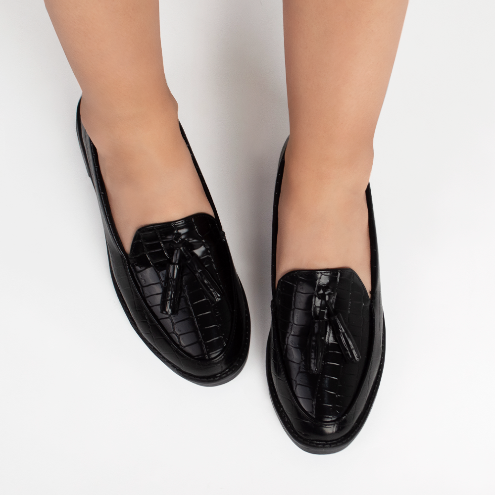 Mocasines negros de material sintético con relieve para dama con borlas decorativas en el empeine  y suela de piso 