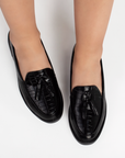 Mocasines negros de material sintético con relieve para dama con borlas decorativas en el empeine  y suela de piso 