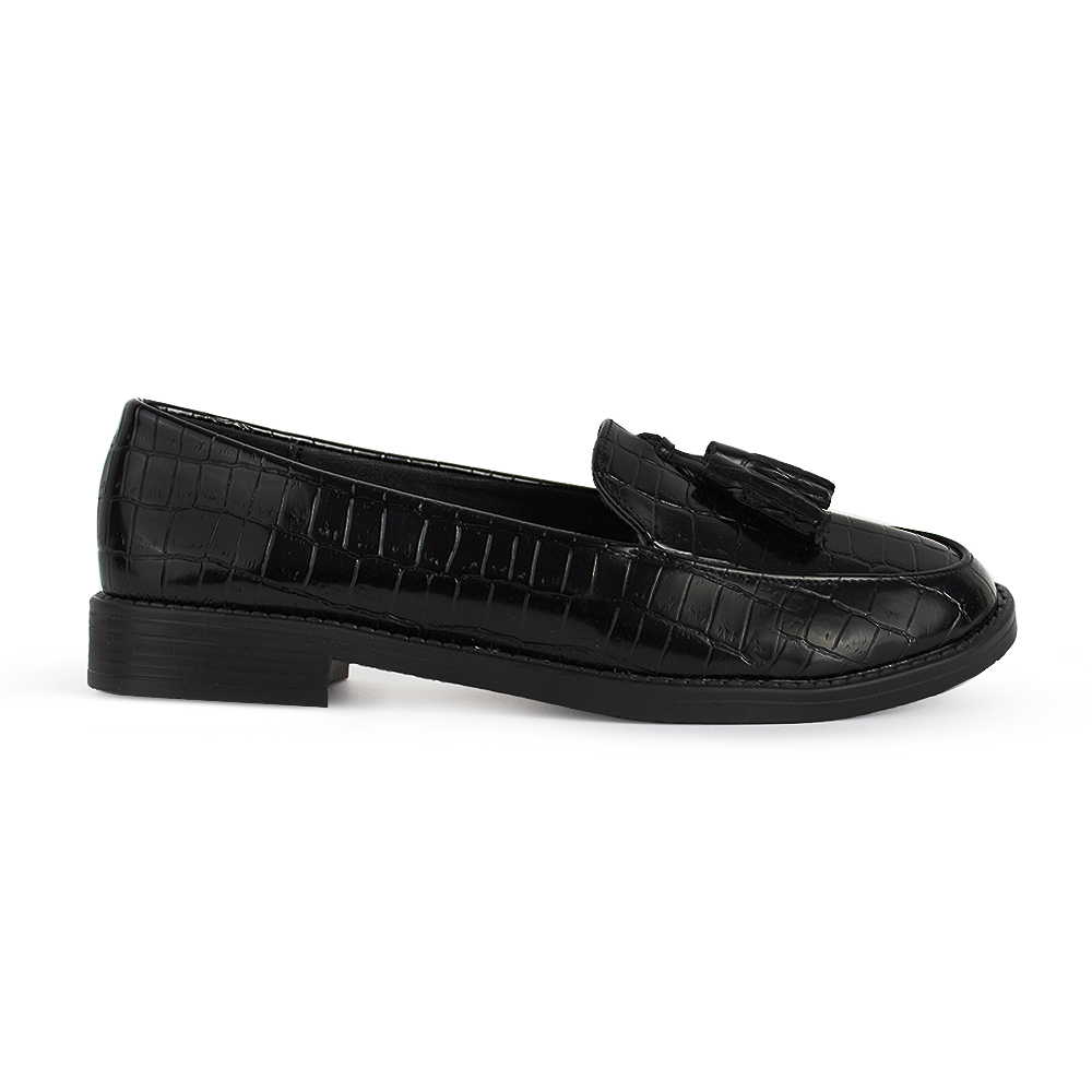 Vista lateral del mocasín negro de material sintético con relieve y borlas decorativas de piso para dama 