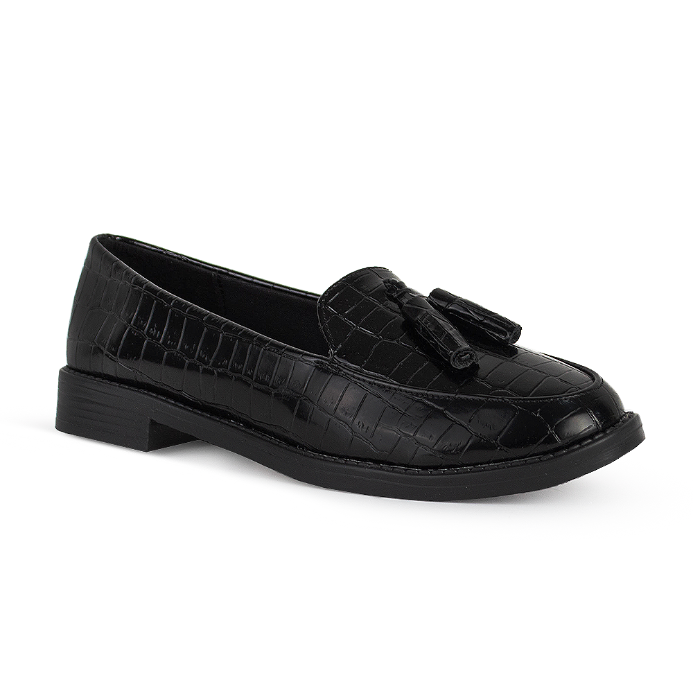 Vista diagonal del mocasín negro de material sintético con relieve para dama con suela de piso y borlas decorativas
