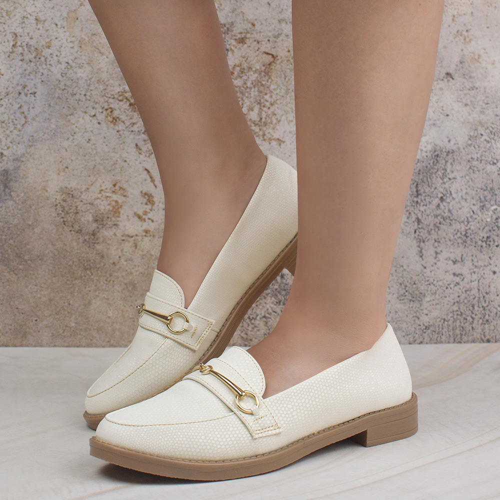 Mocasines beige casuales para dama de piso con herraje metálico en el empeine.