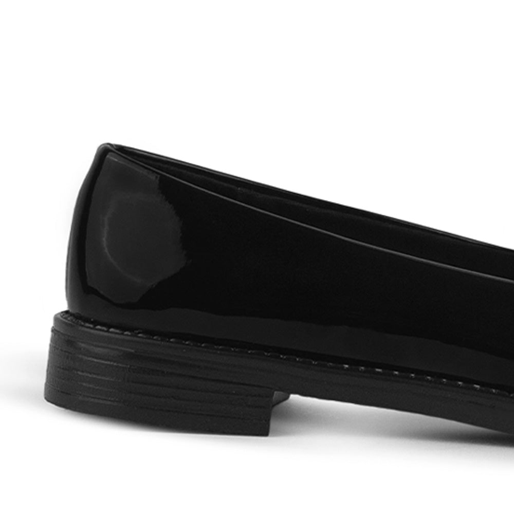 Vista trasera de la suela de piso en mocasín negro de charol con moño decorativo para dama