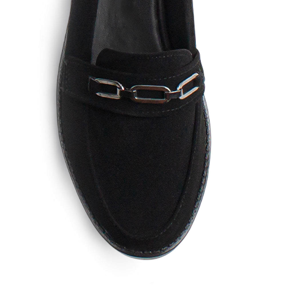 Vista de material buck en mocasín negro para mujer con herraje decorativo en empeine y punta redonda de piso