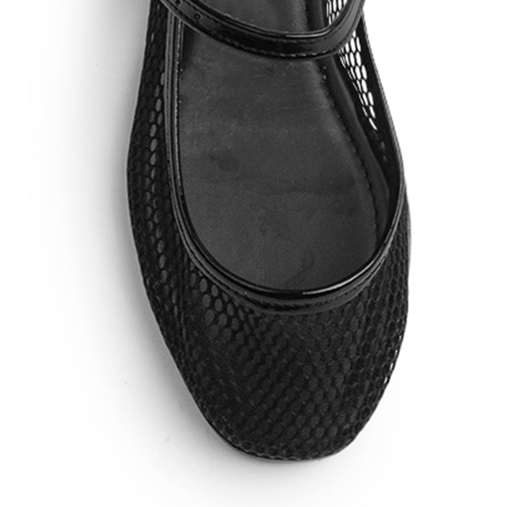 Vista de material sintético en flats negros para mujer con hebilla redonda en correa ajustable tipo balerinas perforadas